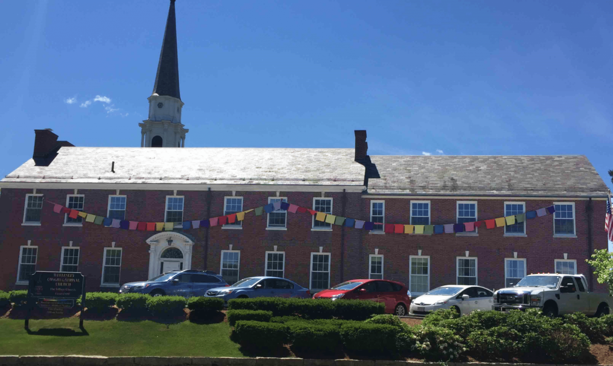 Prayer flags across the facade of the Central St. side of Wellesley Village Church. Photo credit: Village Church